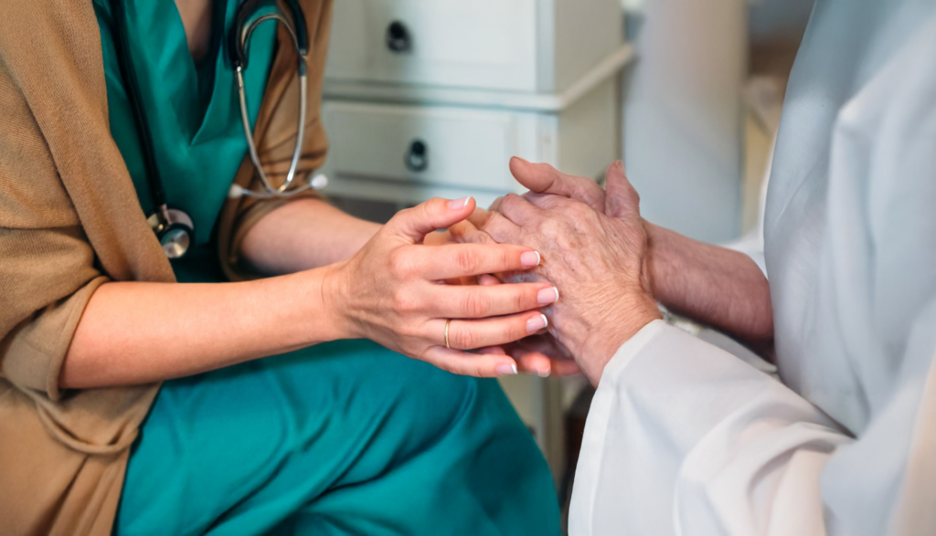 Caregiver comforting aging loved one at home—support for emotional well-being and palliative care